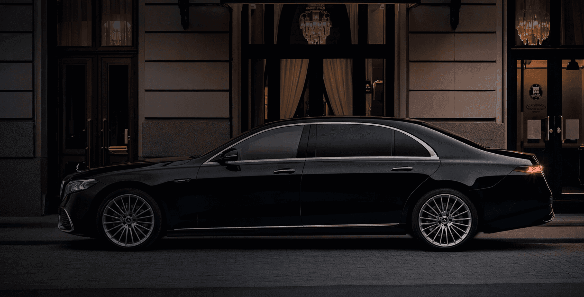Luxury chauffeured sedan in front of an elegant building