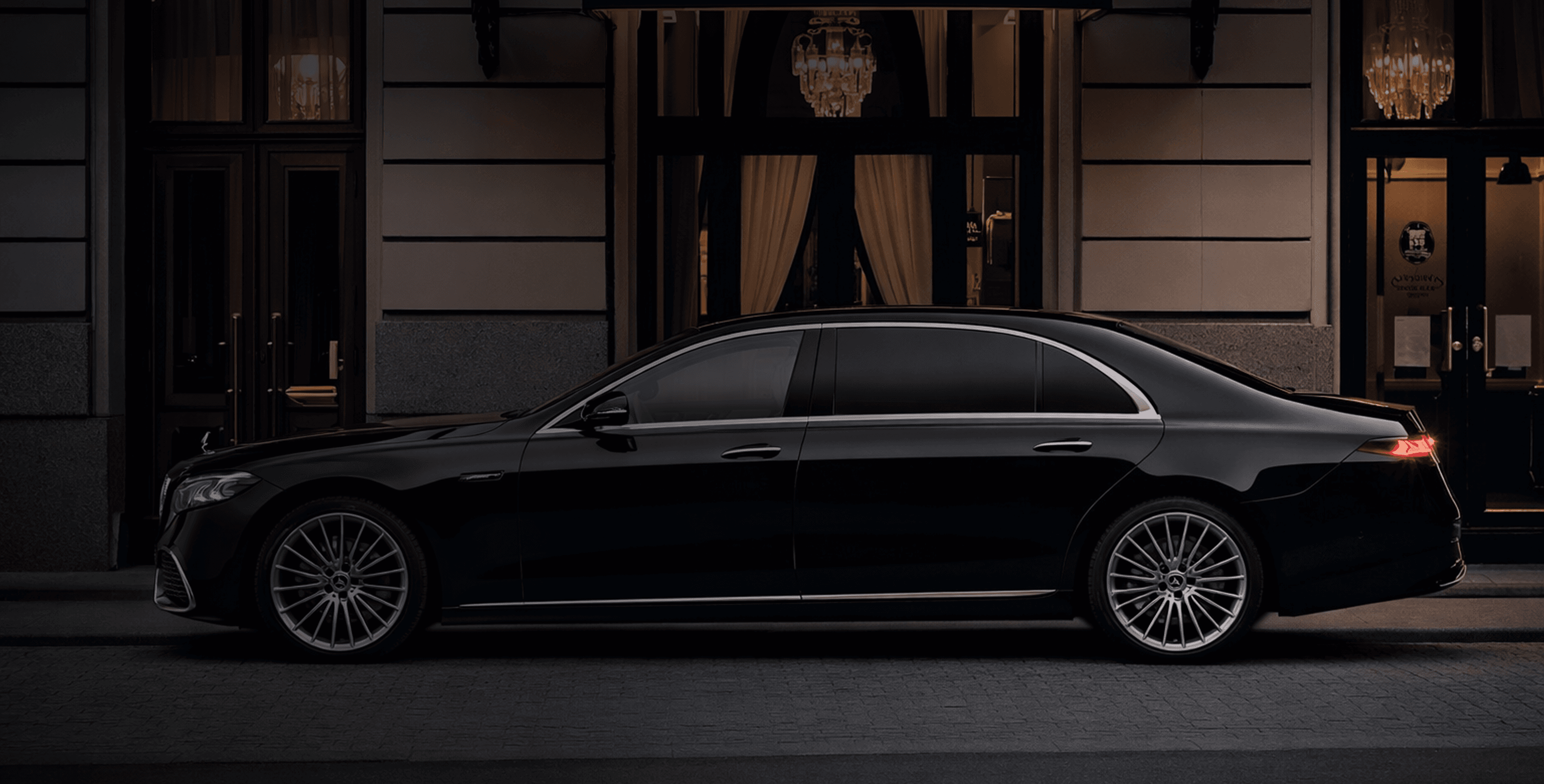 Luxury chauffeured sedan in front of an elegant building